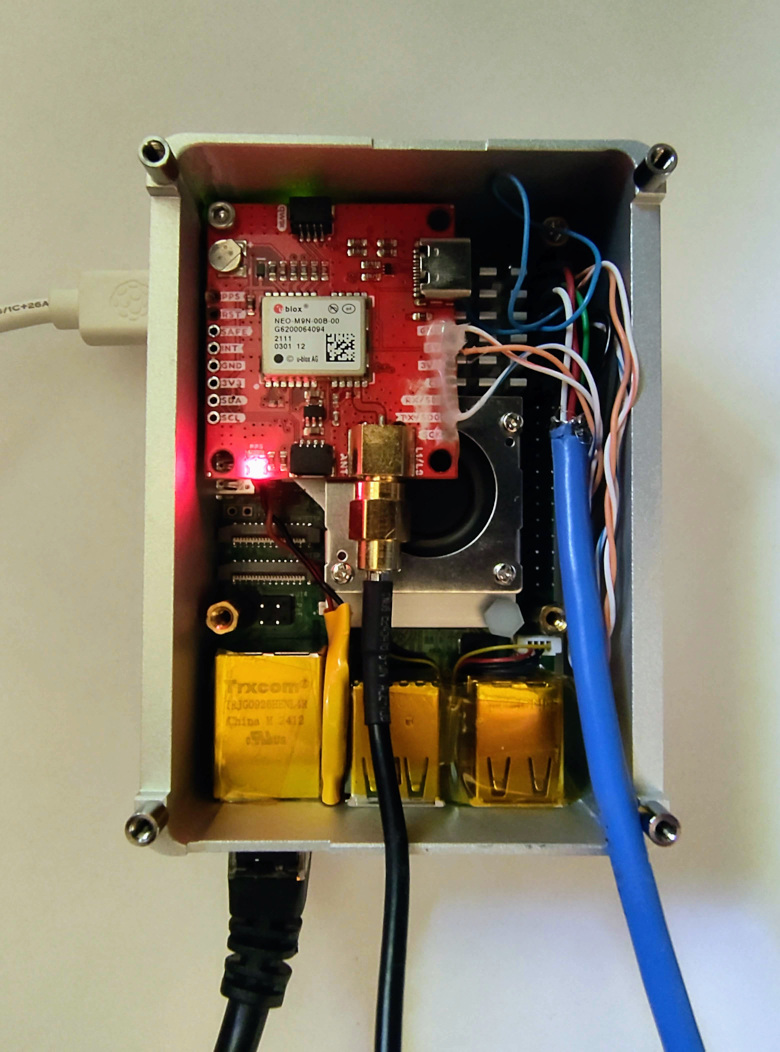 The server's real build: Raspberry Pi 5 and NEO-M9N GNSS board inside the aluminium enclosure.